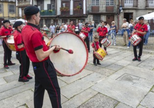 Traditional drum and pipe band perform on city streets on May Day 2025, Guimaraes, Braga district,