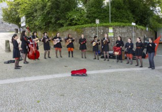Group female university students musicians perform in street, city of Guimaraes, northern Portugal