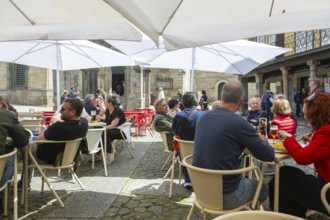 Customers sittimg outside at cafe tables, Largo da Oliveira square, city of Guimaraes, northern
