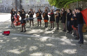 Group female university students musicians perform in street, city of Guimaraes, northern Portugal