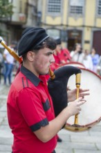 Traditional piper in band performing on city streets on May Day 2025, Guimaraes, Braga district,