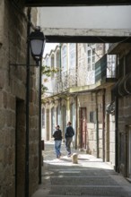Coupe walking exploring alleyways in historic centre of ity of Guimaraes, northern Portugal