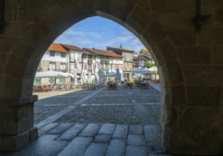View through archway of historic buildings in Praça de São Tiago, city of Guimaraes, northern