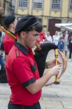Traditional piper in band performing on city streets on May Day 2025, Guimaraes, Braga district,