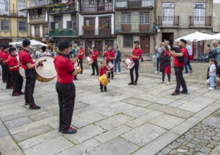 Traditional drum and pipe band perform on city streets on May Day 2025, Guimaraes, Braga district,