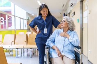 Young nurse assisting and comforting a senior woman in a wheelchair in a hospital waiting room