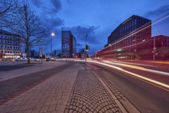 General architecture, modern building, bare wintry trees, traffic lights, pavement made of paving