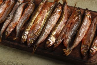 Cold smoked capelin, on a wooden chopping board, no people