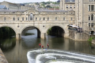 Avon Fire and Rescue Service personnel on weir on River Avon, Pulteney Bridge, city of Bath, north