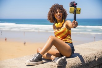 Influencer filming a vibrant vlog on a stunning beach, capturing moments with a smartphone and an
