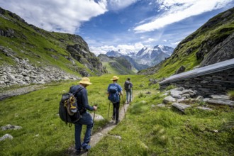 Mountaineer on hiking trail in mountain landscape, descent from Col du Louvie, view of glaciated
