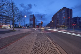 General architecture, modern building, bare wintry trees, traffic lights, pavement made of paving