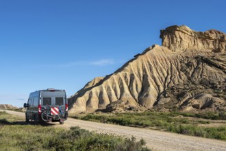 Colorful rock formation, camper van, semi-desert, Bardena Blanca area, Bardenas Reales Nature Park,