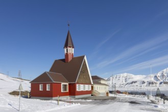 1958 red wooden Evangelical Lutheran Svalbard Church in the town Longyearbyen in winter,