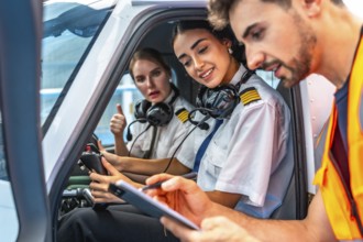Ground crew writing on clipboard while explaining pre flight checklist to two smiling female pilots
