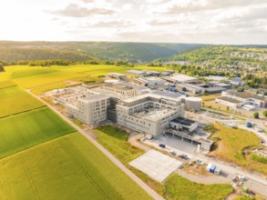 Modern building complexes next to green fields and a picturesque landscape, construction of the new