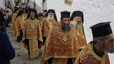 A group of priests in traditional gold and red robes walk during a procession, Orthodox ceremony,
