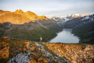 Mountaineer on the summit of Mont de la Blana, alpenglow at sunset, view of a blue mountain lake,