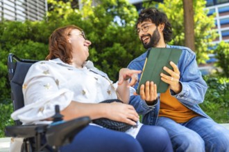 Happy woman with disability using tablet with her friend, modern lifestyle and inclusion concept,