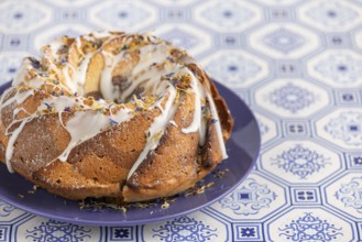 Marble bundt cake, cake with icing and edible flowers on a blue plate