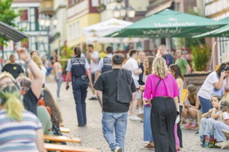 Street scene with people and policemen during a summer entertainment in the city, railway station