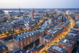 Aerial view of the Speicherstadt Hamburg at blue hour with churches and Alster in the background,