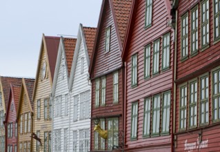 Row of colourful wooden houses with red roofs and rows of windows in Scandinavian style, Bergen,