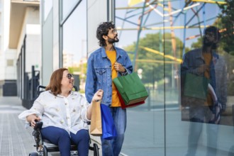 Smiling couple with shopping bags walking by a storefront window, enjoying a day of shopping