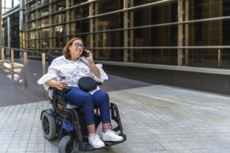 Happy businesswoman using a smartphone in a wheelchair, enjoying a moment of connectivity in the