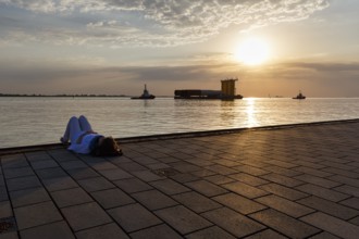 Tourist enjoying the view, sunset on the Weser, pier Seebäderkaje, pontoon, Willy-Brandt-Platz,