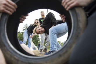 Festival visitors look through a car tyre on a campsite at the Rock am Ring Festival on Saturday,