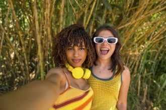 Two cheerful female friends capturing a joyful selfie while enjoying their vacation in a lush