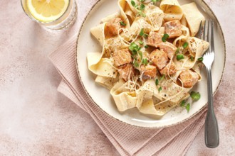 Tagliatelli pasta, with salmon slices and herbs, on a decorative plate, homemade, no people