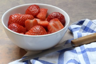 Sliced strawberries in hull with kitchen knife, Fragaria