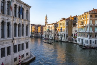 View of the Grand Canal with gondoliers at sunset, picturesque evening mood with palazzos on the