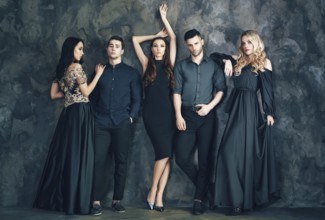 Group of young beautiful people posing in studio. Fashion photo concept