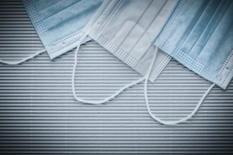 Medical disposable sterile masks on striped background top view