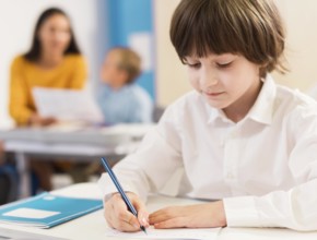 Kid writing his notebook during class