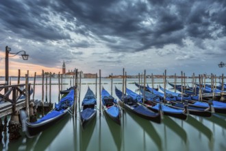Gondolas on St Mark's Square in Venice, Italy, during a dramatic sunrise, Europe