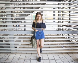 Young woman with bag using tablet university