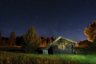 Wooden barn under a nigth sky full of stars
