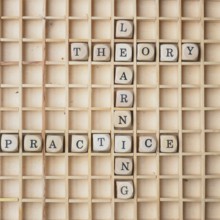 Learning concept with wooden dices and the words theory and practice