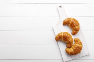 Traditional french croissant on white wooden table, tasty breakfast