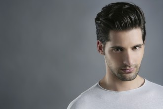 Fashion trendy young man silver futuristic portrait over gray