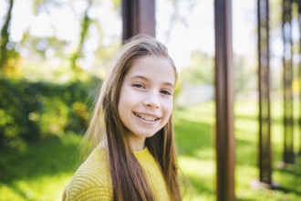 Beautiful teenage girl wearing braces smiling cheerfully dressed in bright yellow clothes outdoors.