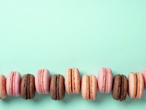 Macarons with copy space. Row of perfect french macarons or macaroons on blue turquoise background.