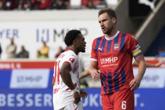 Football match, Lois OPENDA RB Leipzig left with captain Patrick MAINKA 1.FC Heidenheim in opposite