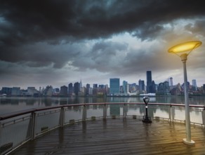 Manhattan New York cloudy dramatic skyline sunset from East River dusk USA