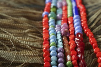Color stones jewelry necklaces over natural straw and tulle background