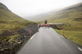 Road construction site on the Faroe Islands with road block sign and digger, Streymoy, Faroe
